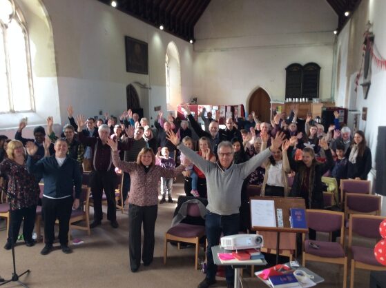 Church room full of waving people